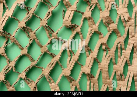 Abstrakte grüne Textur mit geschnittenem Wabenpapier aus braunem Wellpappe Stockfoto