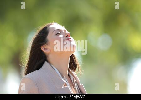 Frau atmet frische Luft in einem sonnigen Park Stockfoto