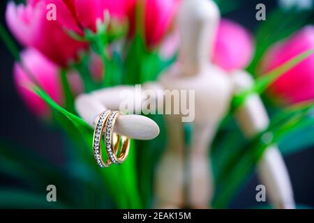 Holzfigur mit zwei goldenen Ehering Stockfoto