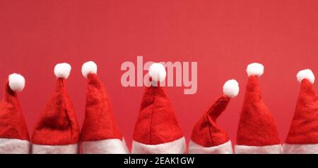 Hut von Santa in einer Reihe auf rot Stockfoto