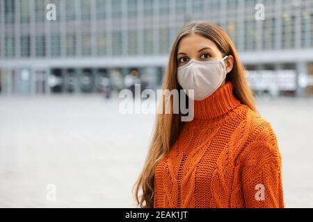 Porträt einer jungen Geschäftsfrau mit Schutzmaske auf der Straße stehend und vor ihr besorgt. Speicherplatz kopieren. Stockfoto