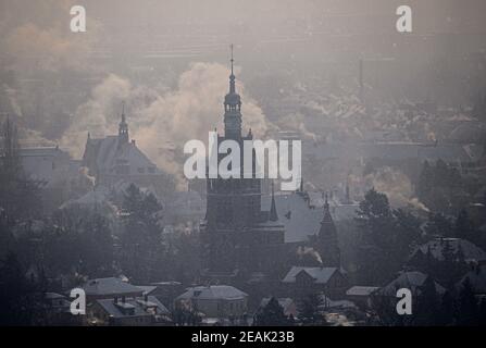 Radebeul, Deutschland. Februar 2021, 10th. Der Dampf der Lößnitzbahn und der rauchenden Kamine steigt an diesem winterlich kalten Tag rund um die Lutherkirche. Quelle: Robert Michael/dpa-Zentralbild/dpa/Alamy Live News Stockfoto