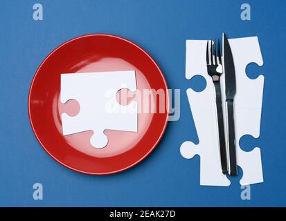 Rote runde Keramikplatten, Gabel mit Messer auf blauem Hintergrund Stockfoto