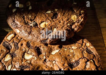 Nahaufnahme von rustikalen Schokoladennuss-Keksen, die sichtbare Stücke von dunkler Schokolade und zerstoßenen Nüssen in der Mischung zeigen. Stockfoto