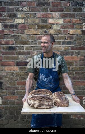 GROSSBRITANNIEN / England / Hertfordshire /Duchess Farms/ Kunsthandwerker, der Brote hält. Stockfoto