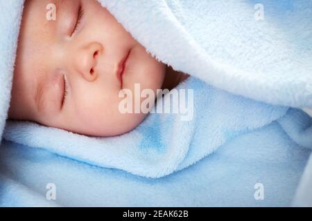 drei Monate altes Baby schlafen auf blaue Decke Stockfoto