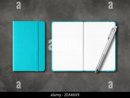 Aqua blau geschlossene und offene linierte Notizbücher mit einem Stift Auf dunklem Betongrund Stockfoto