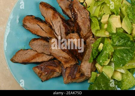 Gegrilltes Rindersteak in Scheiben geschnitten und mit Salat serviert Stockfoto