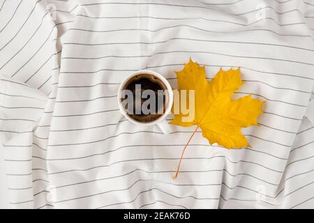 Herbstkomposition. Tasse coffeecup, Herbstblätter auf weißem kariertem Tuch. Flach liegend, Draufsicht, Kopierbereich Stockfoto