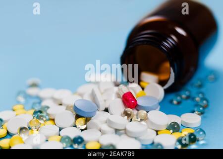 Medizinische Flasche und Medikationspillen verschüttet auf pastellblauen Hintergrund. Gesundheitswesen, Pharmazie, Medizin Konzept Stockfoto