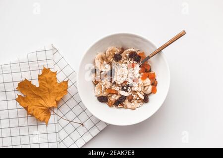 Kohlenhydrate gesundes Frühstück. Haferflocken mit getrockneten Früchten auf einem weißen Teller. Blick von oben Stockfoto