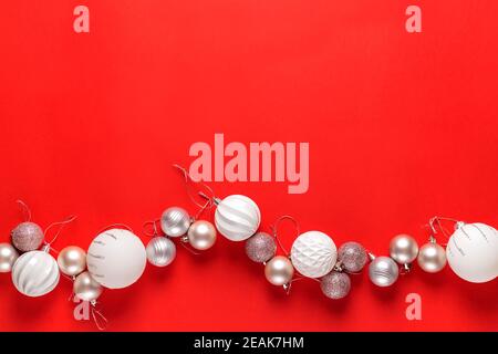 Weiße weihnachtskugeln Dekoration auf rotem Hintergrund. Flach liegend. Urlaubskonzept. Stockfoto