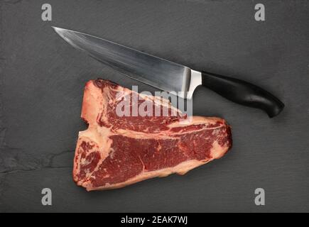 Nahaufnahme rohes Rindfleisch T-Bone Steak auf Schiefertafel Stockfoto