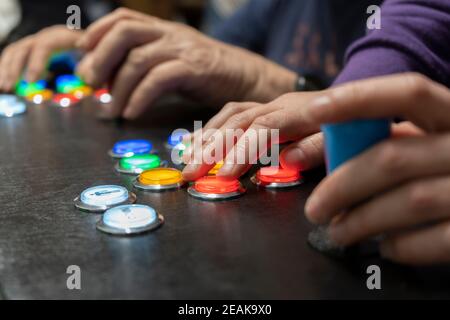 Nahaufnahme Ansicht von zwei Menschen Hände spielen Arcade vintage Video Games.Gamepad mit Joystick und viele bunte Tasten .spielerische Freunde, Spaß und Hobbys Stockfoto