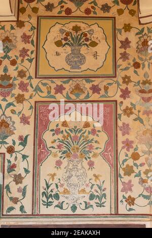 Dekoratives Design und Blumenbilder an der Wand von Amber Palace, Jaipur, Rajasthan, Indien. Stockfoto