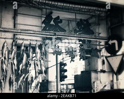 SHANGHAI, CHINA - 01. Feb 2021: Fische hängen in einem Markt mit Verkehrsschildern Stockfoto