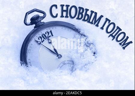 2021 Neujahrskarte, Frohe Neujahrsgrüße in russischer Sprache, Taschenuhr im Schnee, Countdown bis Mitternacht Stockfoto