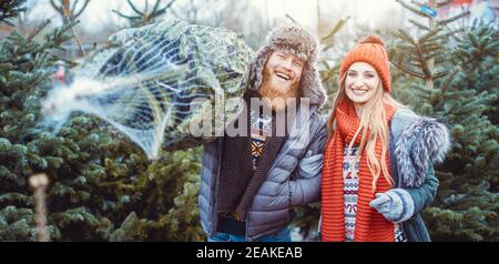 Mann und Frau haben einen Weihnachtsbaum gekauft Stockfoto