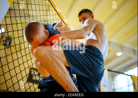 MMA Fighter führt Knieschlag auf seinen Gegner Stockfoto