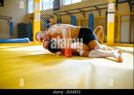 MMA Fighter übt schmerzhaften Halt an seinem Gegner aus Stockfoto