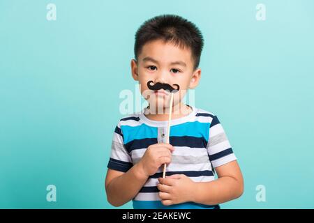 Lustige glücklich Hipster Kind hält schwarzen Schnurrbart Stockfoto