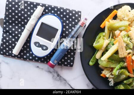 Diabetische Messwerkzeuge und Insulin Stift und gesunde Ernährung auf Tabelle Stockfoto