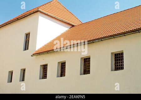 Bild von einem roten Ziegeldach auf einem alten Haus Mit Gitterfenstern Stockfoto