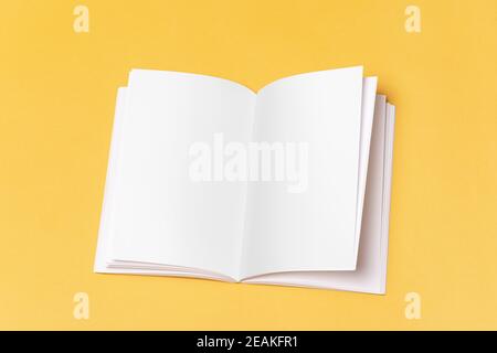 Geöffneter Buchkatalog mit leeren Seiten auf gelbem Hintergrund Nachbildung Serie 271 Stockfoto