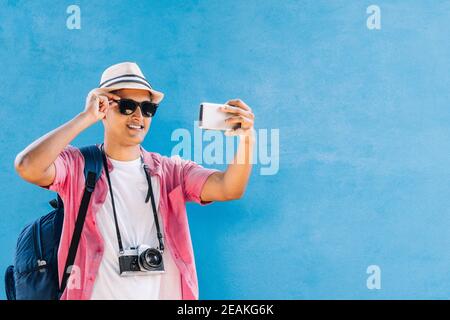 Lateinamerikanisch lächelnd mit Brille und Hut beim Selfie Stockfoto