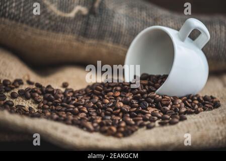 Kaffeebohnen verschüttet aus Tasse Stockfoto