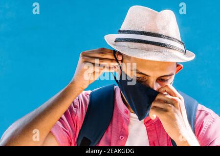 Junger Mann, der seine Maske auszieht. Stockfoto