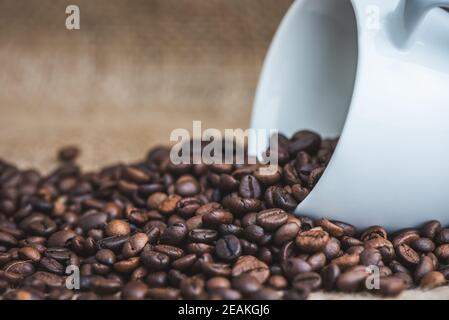 Kaffeebohnen verschüttet aus Tasse Stockfoto