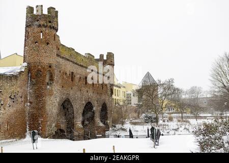 ZUTPHEN, NIEDERLANDE - 08. Feb 2021: Brücke über den Fluss Berkel der mittelalterlichen Hansestadt während eines Schneesturms mit Überresten der Berkelpoort-Stadt wa Stockfoto