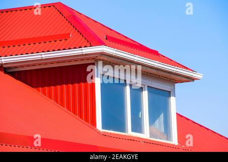 Haus mit Kunststoff Fenstern und einem roten Dach aus Wellblech Stockfoto