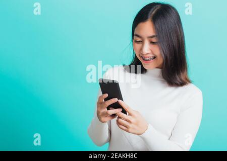 Frau lächeln sie halten und tippen Textnachricht Stockfoto