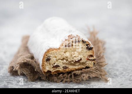 Christstollen, traditioneller weihnachtskuchen mit Nüssen, Rauten, Marzipan auf blauem Hintergrund, leerer Platz für Text Stockfoto