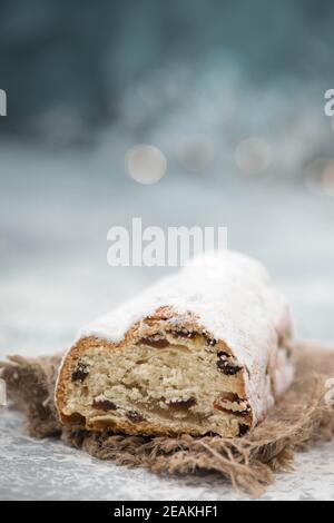 Christstollen, traditioneller weihnachtskuchen mit Nüssen, Rauten, Marzipan auf blauem Hintergrund, leerer Platz für Text Stockfoto