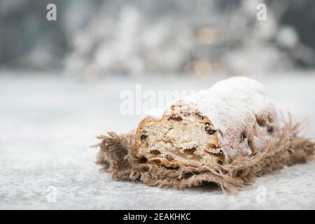 Christstollen, traditioneller weihnachtskuchen mit Nüssen, Rauten, Marzipan auf blauem Hintergrund, leerer Platz für Text Stockfoto