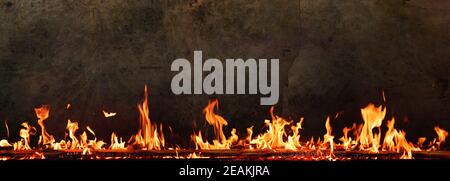 Feuer flammt vor dunkler Betonwand Stockfoto