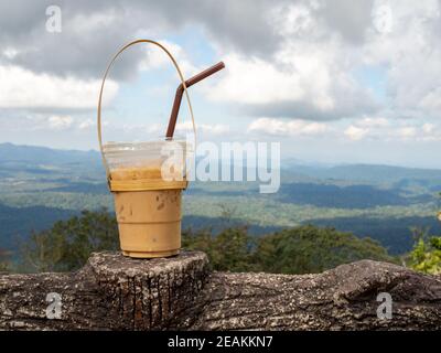 Ein Glas Thai-Tee auf einem Berg Hintergrund in Khao Yai Nationalpark Stockfoto