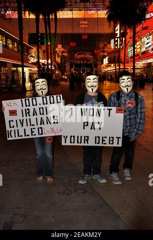 Die Demonstranten der Occupy Las Vegas-Bewegung tragen Guy Fawkes-Masken und halten Protestschilder auf der Fremont Street in Las Vegas, Nevada, USA. Stockfoto