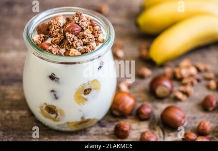Joghurt mit Müsli, Banane und Nüssen Stockfoto