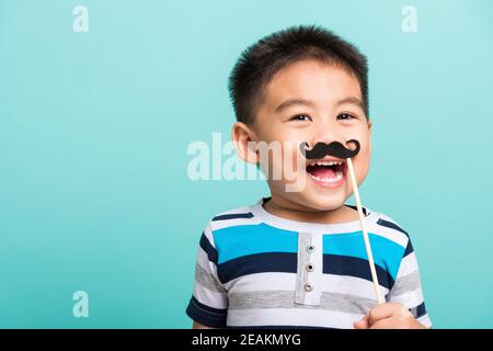 Lustige glücklich Hipster Kind hält schwarzen Schnurrbart Stockfoto