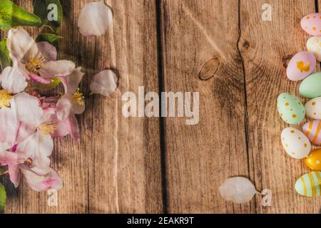 Nahaufnahme von oben Blick auf bunte Ostereier auf einem hölzernen Oberfläche mit frisch gepflückten Blumen Stockfoto