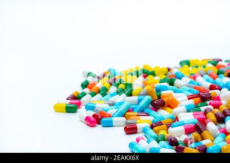 Haufen von mehrfarbigen Antibiotika-Kapsel Pillen auf weißem Hintergrund. Antibiotikaresistenz. Antimikrobielle Medikamente. Pharmaindustrie. Antibiotische Drogenkonsum mit vernünftigem Konzept. Gesundheitswesen. Stockfoto