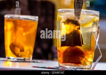 Durchsichtiger Becher mit Tee. Tee im Beutel zubereiten. Stockfoto