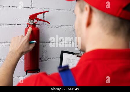 Brandschutz und Brandschutz - Service-Mitarbeiter Überprüfung Feuerlöscherdruck Stockfoto