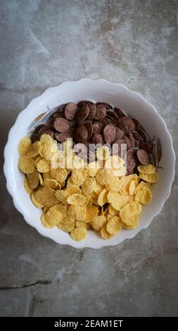 Schüssel mit schwarzen und gelben Getreide auf grauem Hintergrund oben Anzeigen Stockfoto