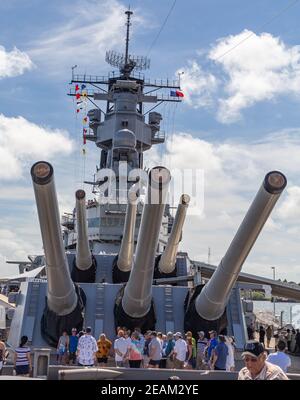 Pearl Harbor, Hawaii, USA - 24. September 2018: Touristen, die an Deck der USS Missouri neben riesigen Kanonen stehen, dockten in Pearl Harbor an. Blauer Himmel mit w Stockfoto