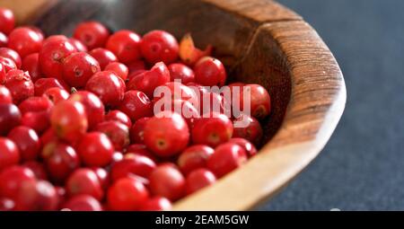 Ganze rosa rote Pfefferkörner in kleiner Holzschale, Nahaufnahme Detail Stockfoto
